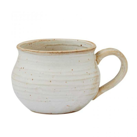 White ceramic mug with brown speckles on a white background